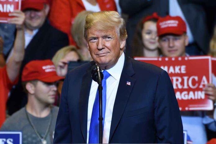 1149680009 featured image Person at a rally with Make America Great Again signs.
