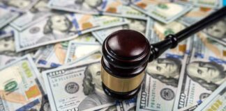 Gavel on pile of hundred dollar bills