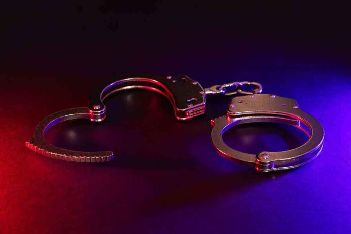 2423548283 featured image Handcuffs with red and blue dramatic lighting.