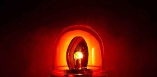 Red emergency light glowing in darkness.