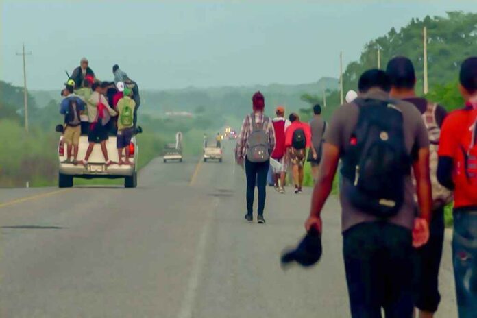 1229072197 featured image People walking and riding on a truck along road.