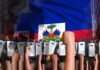 Raised fists and riot police under Haitian flag