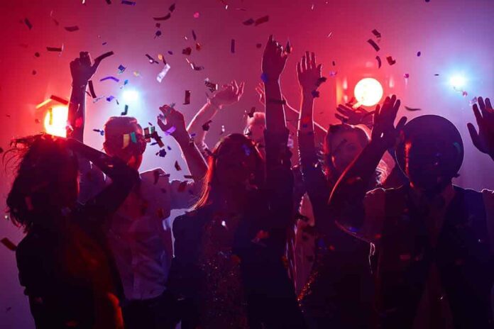 351380480 featured image Partygoers dancing with confetti and colorful lights.