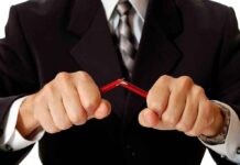 Person breaking red pencil with both hands