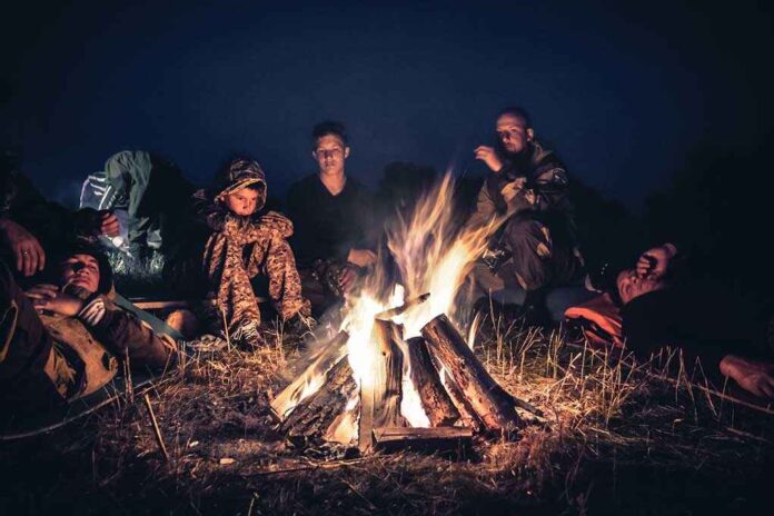 726000778 featured image People sitting around a campfire at night