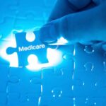 Hand placing Medicare puzzle piece under blue light