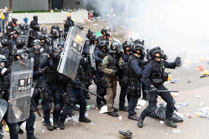 1425188288 featured image Police in riot gear holding shields and batons.