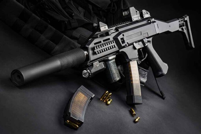 1512787109 featured image Black assault rifle with silencer and magazine on dark background.