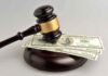 Gavel resting on hundred dollar bills