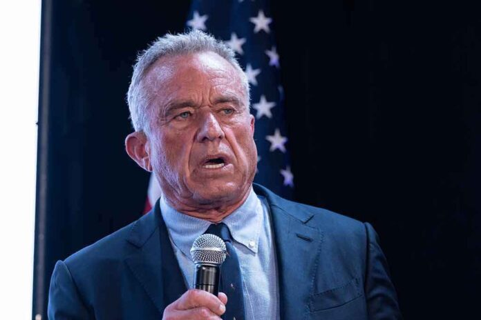 2456684675 featured image Man holding microphone speaking with American flag behind