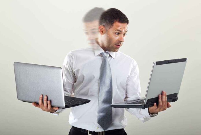 532697098 featured image Man holding two laptops andlooking surprised