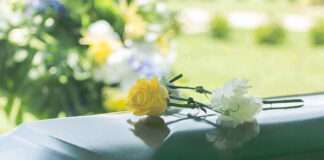 Flowers on a closed casket at a funeral