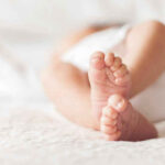 Close-up of baby feet lying on blanket