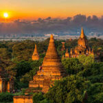 Deadly Border Clash Shakes Southeast Asia Sunset over ancient temple complex with lush greenery