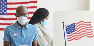 People voting with masks and gloves at polling station.