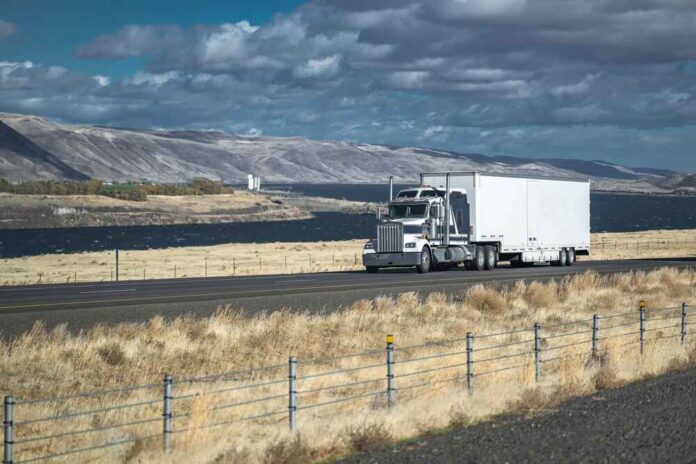 2262168801 featured image Truck driving on rural highway near river and mountains