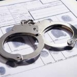 Handcuffs on fingerprint form with fingerprints visible