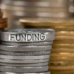 Stack of coins labeled funding with other coins stacks