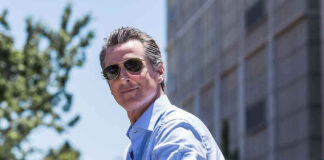 Man in sunglasses wearing a blue button-up shirt.