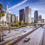Leaders Urging Trump to Focus on L.A. Crime Next Downtown cityscape with skyscrapers and highway traffic.