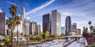 Downtown cityscape with skyscrapers and highway traffic.