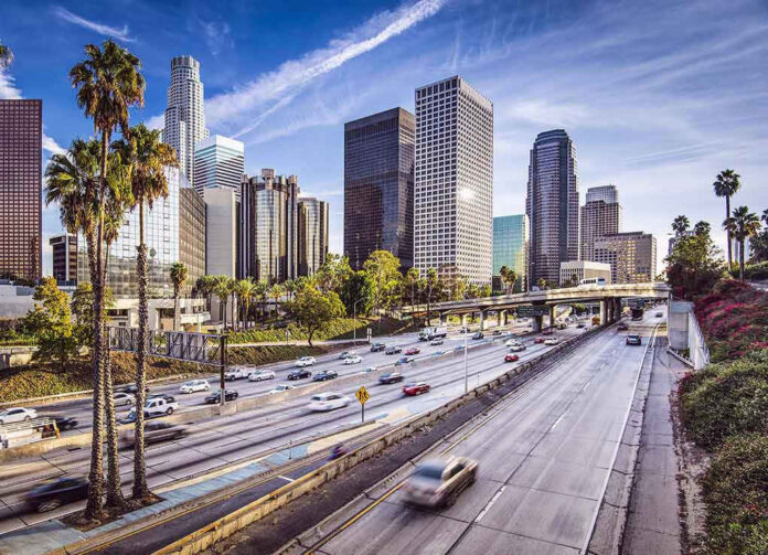 Downtown cityscape with skyscrapers and highway traffic.