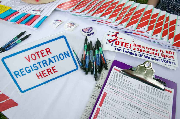 Voter registration table with forms, pens, and brochures.