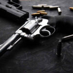 Revolvers and bullets on a dark surface
