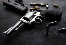 Revolvers and bullets on a dark surface
