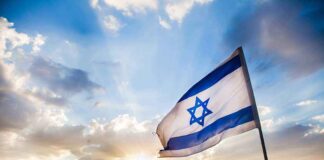 Israeli flag waving against a sunset backdrop with clouds
