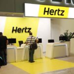 Hertz car rental counter at an airport with customers checking in