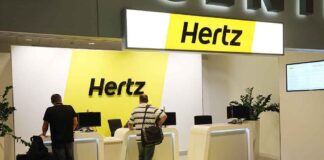 Hertz car rental counter at an airport with customers checking in