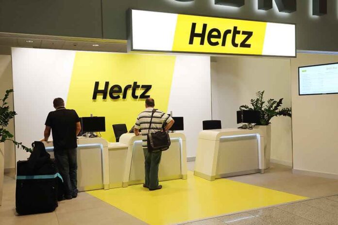 Hertz car rental counter at an airport with customers checking in