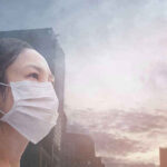 Person wearing a mask in a cityscape background.