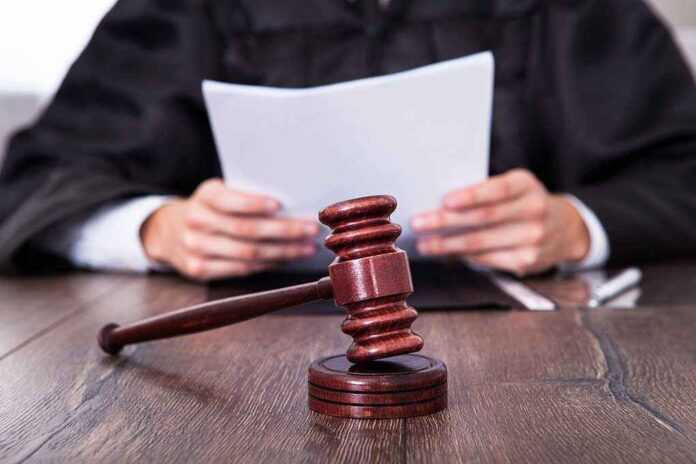 shutterstock_164106293.jpg A judge holding documents with a gavel in the foreground