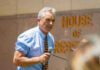 Man speaking into microphone outside House of Representatives