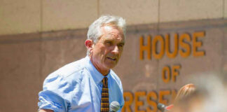 Man speaking into microphone outside House of Representatives