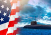 American flag and submarine at sea under a cloudy sky