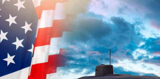 American flag and submarine at sea under a cloudy sky