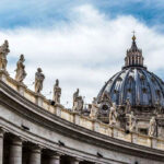 St Peters Basilica dome with statues and clouds