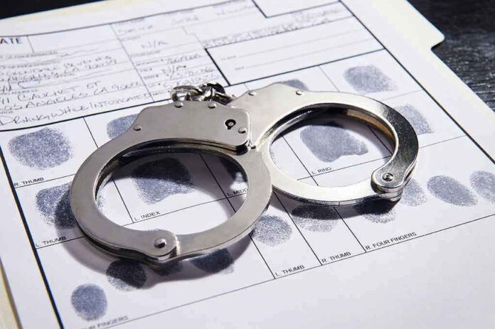 608376650 Handcuffs on fingerprint form with fingerprints visible