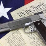 A handgun placed on top of the US Constitution and an American flag