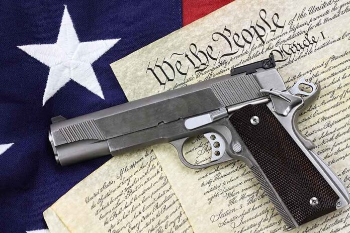 shutterstock_129482747.jpg A handgun placed on top of the US Constitution and an American flag