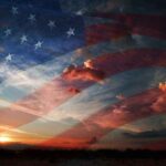 A sunset with an overlay of the American flag and dramatic clouds