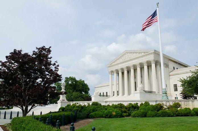The US Supreme Court building with an American flag and landscaped grounds