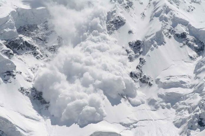 An avalanche occurring on a snowy mountain slope