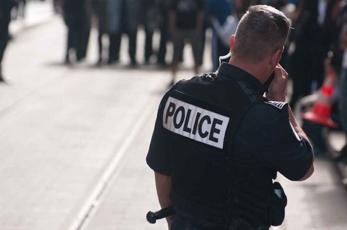 Police officer in uniform communicating with a crowd in an urban setting