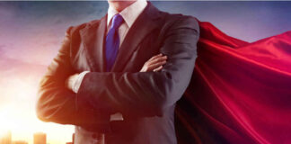 Businessman wearing a cape, standing confidently.