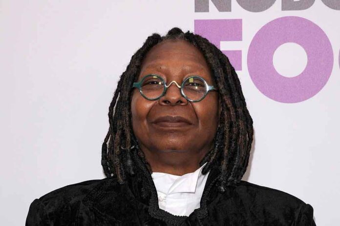 A person with dreadlocks wearing glasses and a black outfit at a red carpet event