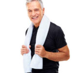 Smiling older man wearing a black shirt with a towel around his neck